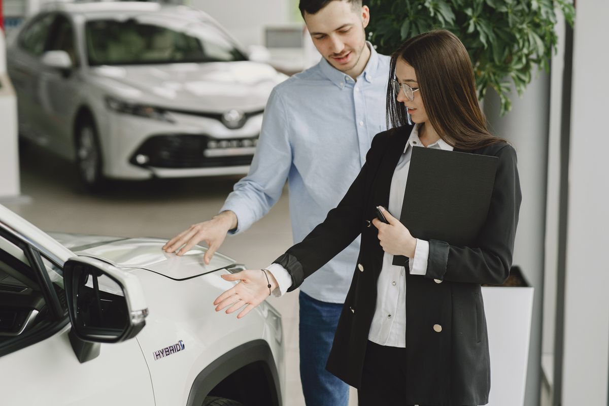 Verkoopadviseur laat een auto zien aan klanten in de showroom